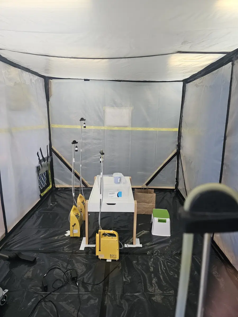 Air sampling pumps on tripods inside the enclosure before removal starts