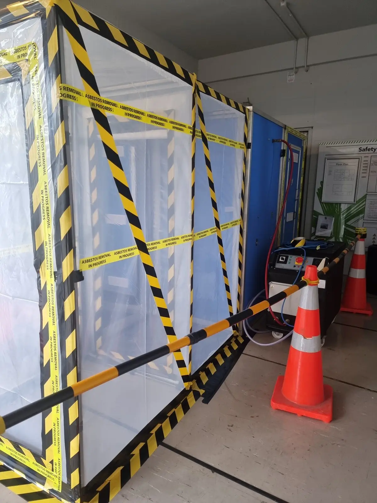 Asbestos airlock entry marked with yellow and black tape and cones