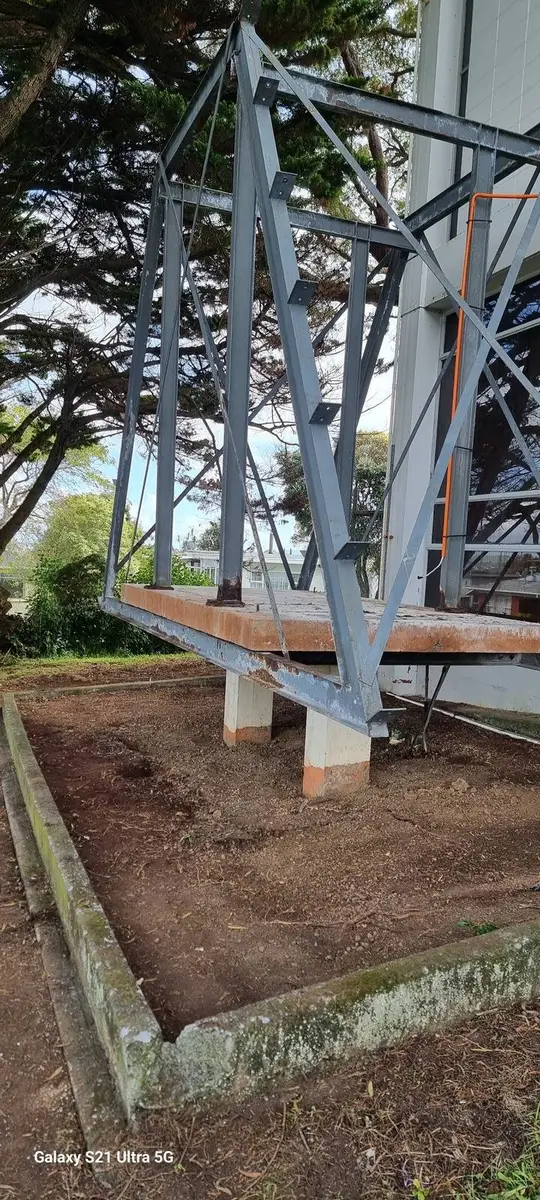 Bare steel frame on the lawn after the asbestos-cement hood was removed