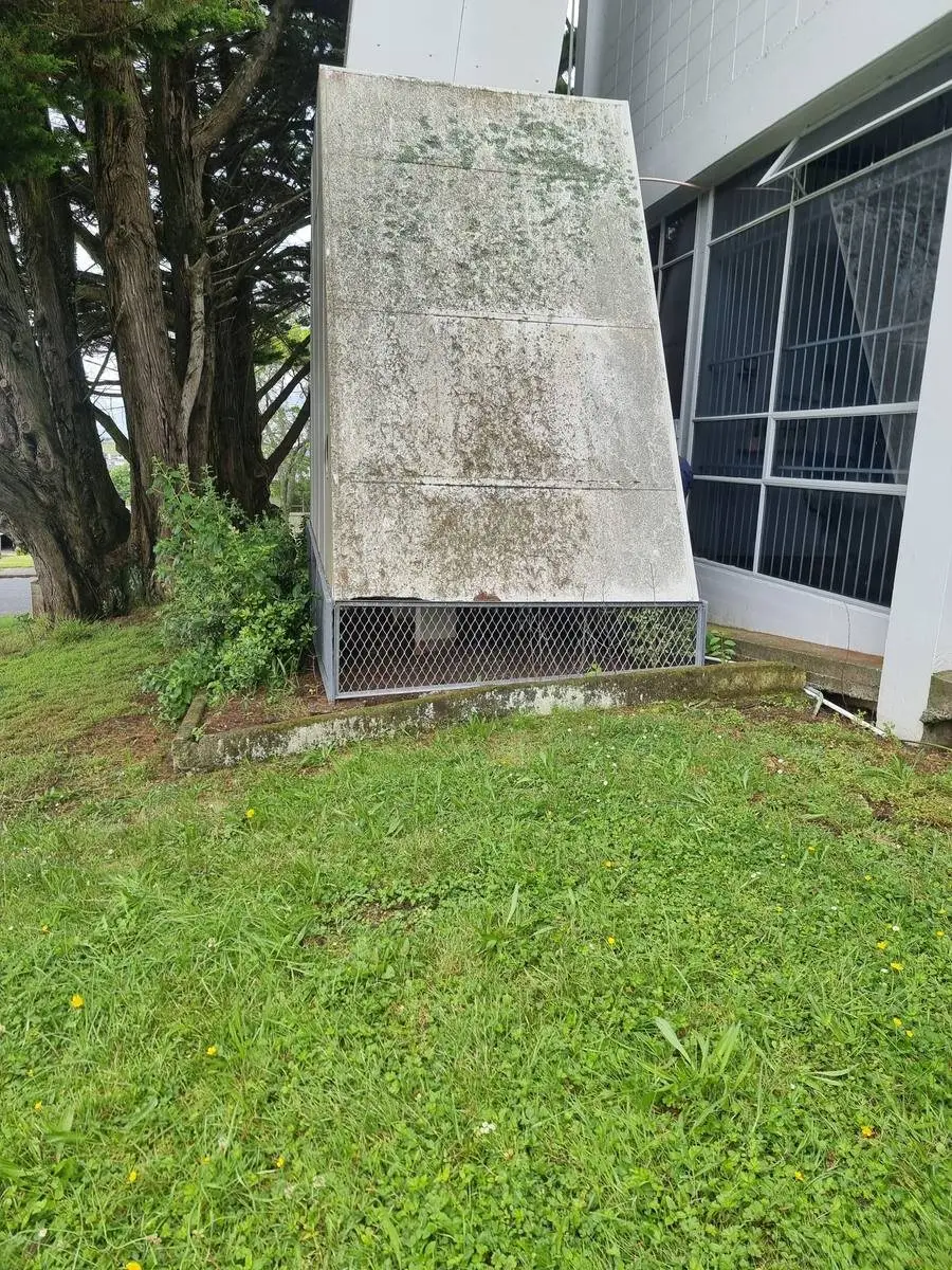 Asbestos-cement vent hood from the lawn side of the commercial building