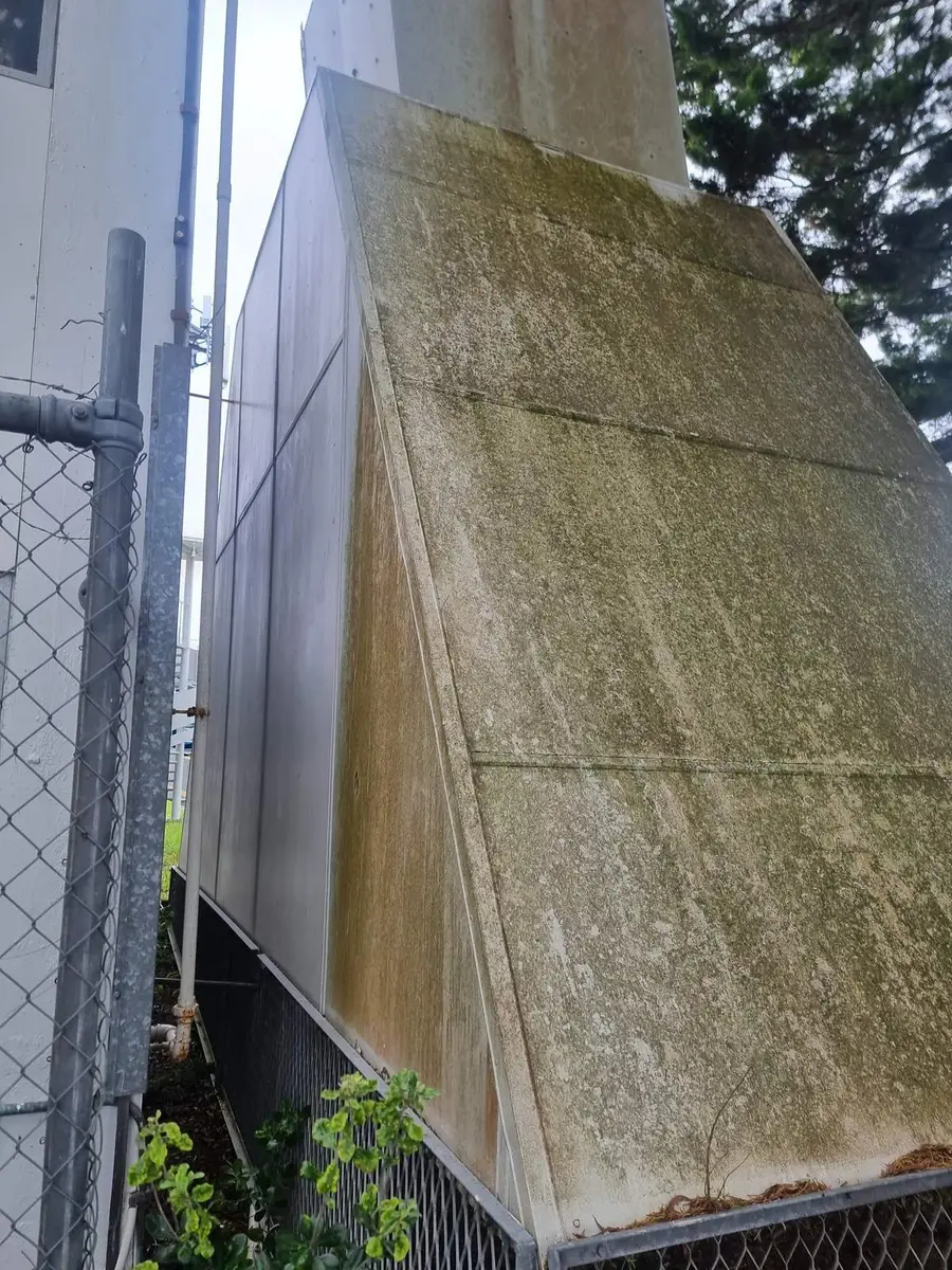 Side view of the asbestos-cement ventilation hood and its steel support frame before removal