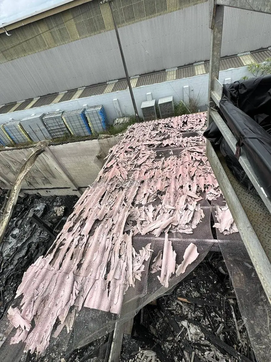 Asbestos-contaminated insulation laid on poly sheeting for wrapping and disposal