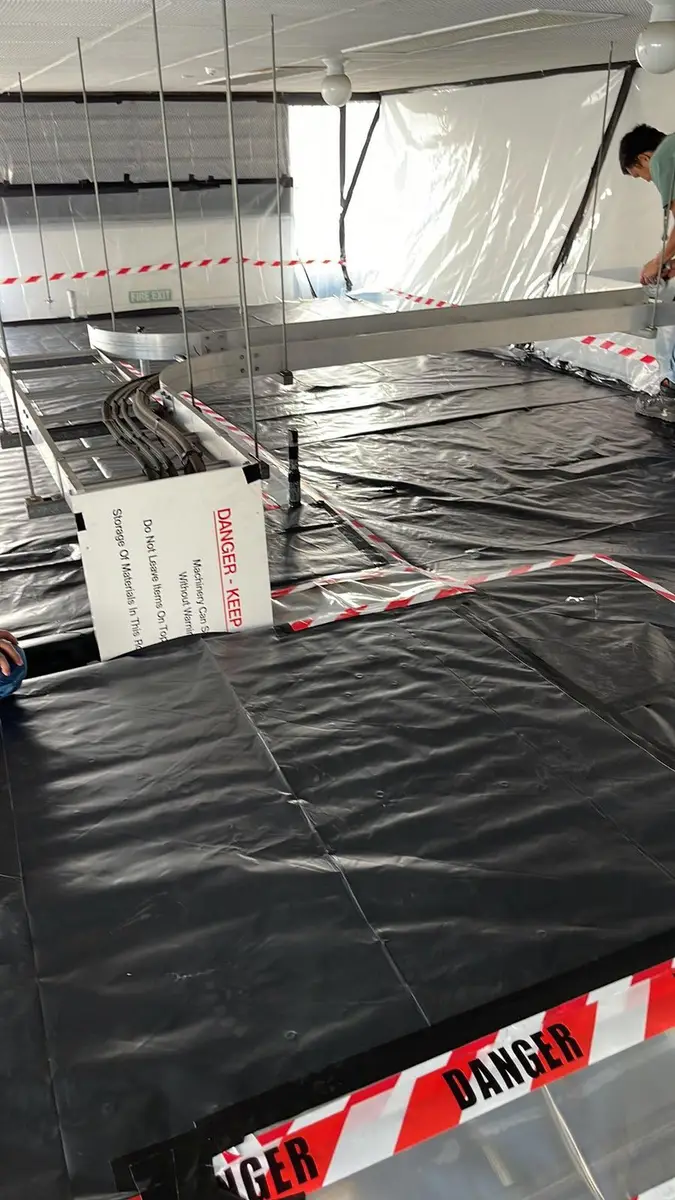 Asbestos enclosure with danger tape and black poly floor