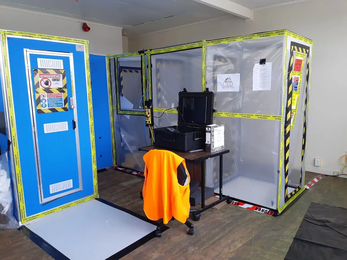 Asbestos enclosure with decontamination unit and air monitoring