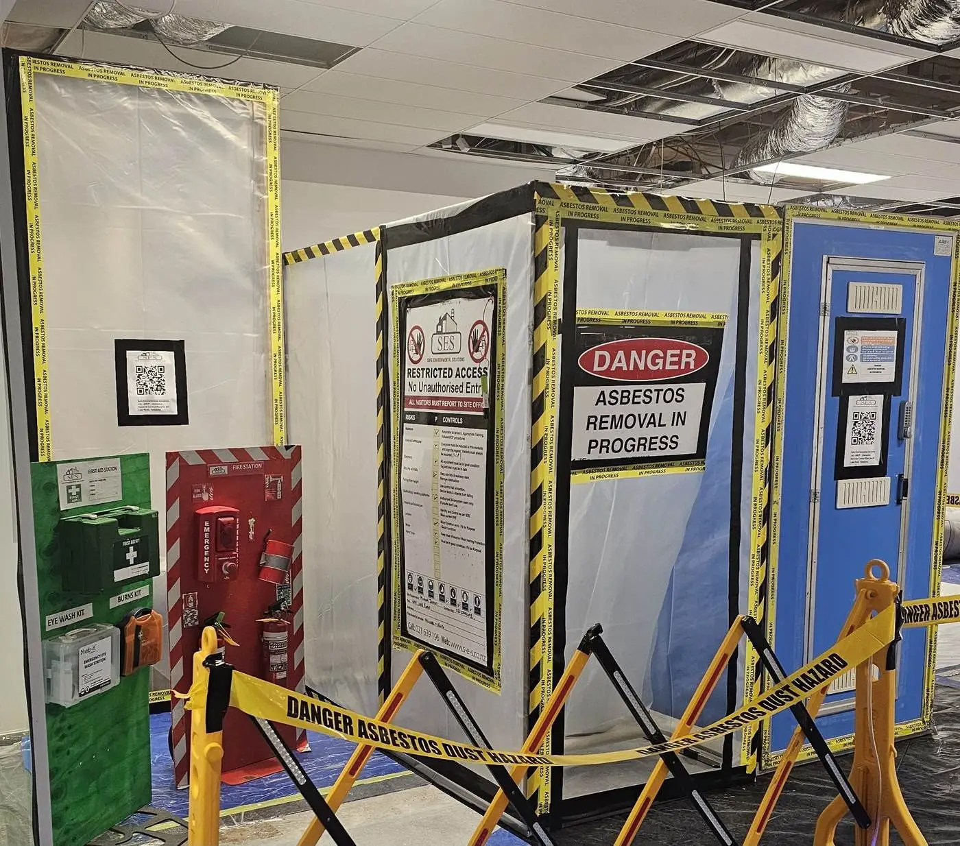 Asbestos enclosure and decontamination unit behind barriers ahead of the fit-out
