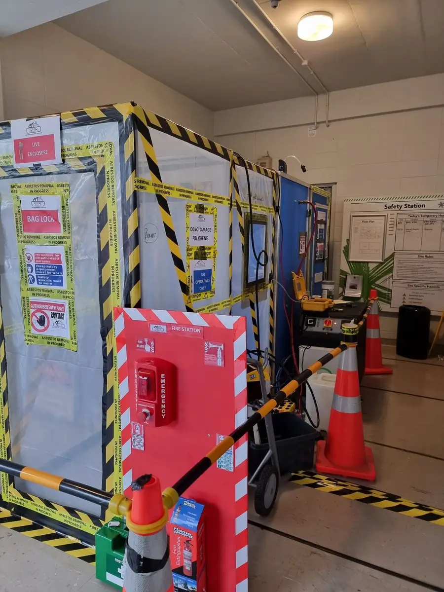 Enclosure entry with decontamination unit, first aid and fire equipment