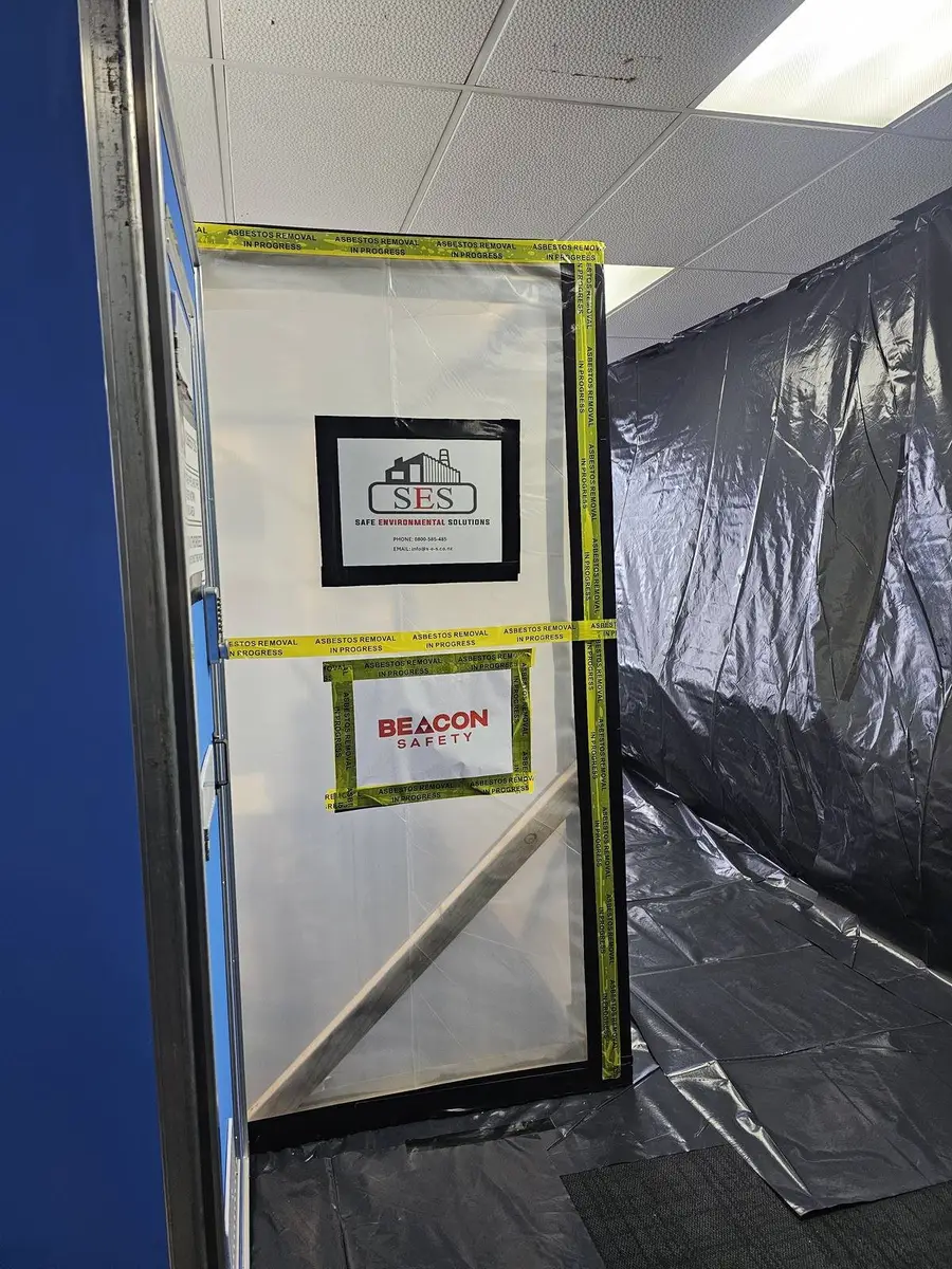 Entry door to the asbestos enclosure with SES and independent assessor signage