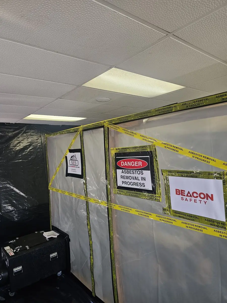 Exterior of the asbestos enclosure with danger signage in the office