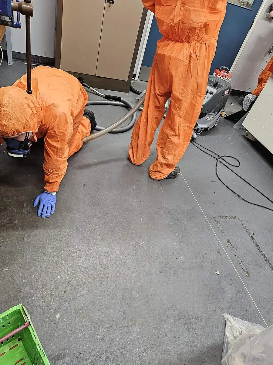 Operative crouched working on the office floor in PPE
