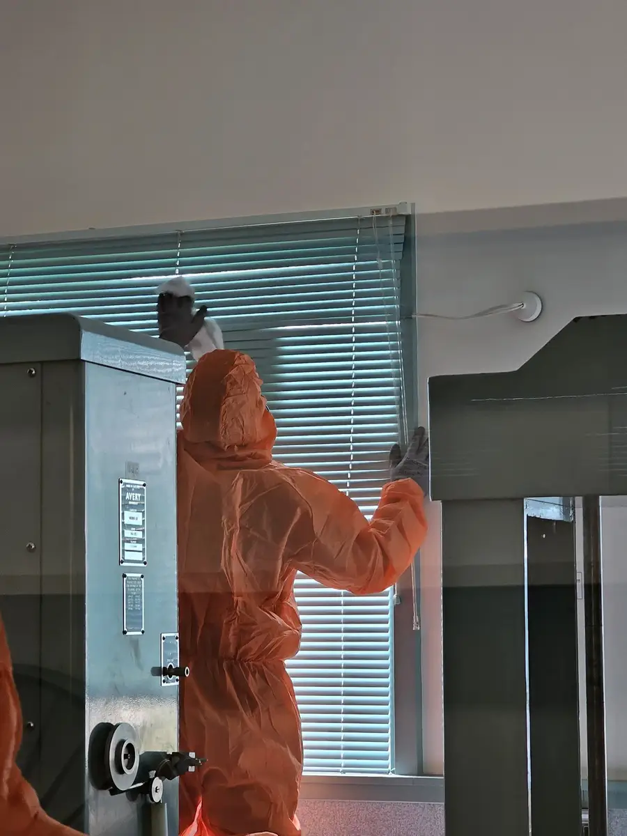 Operative working at the office window during asbestos removal