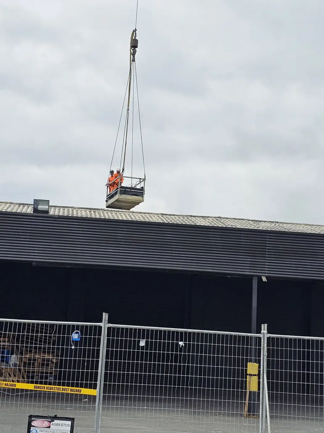 Asbestos roof sheets being craned from the commercial building