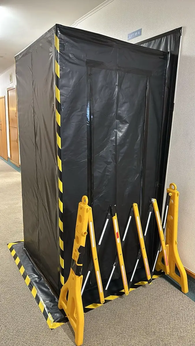Black poly enclosure doorway with barrier in the corridor