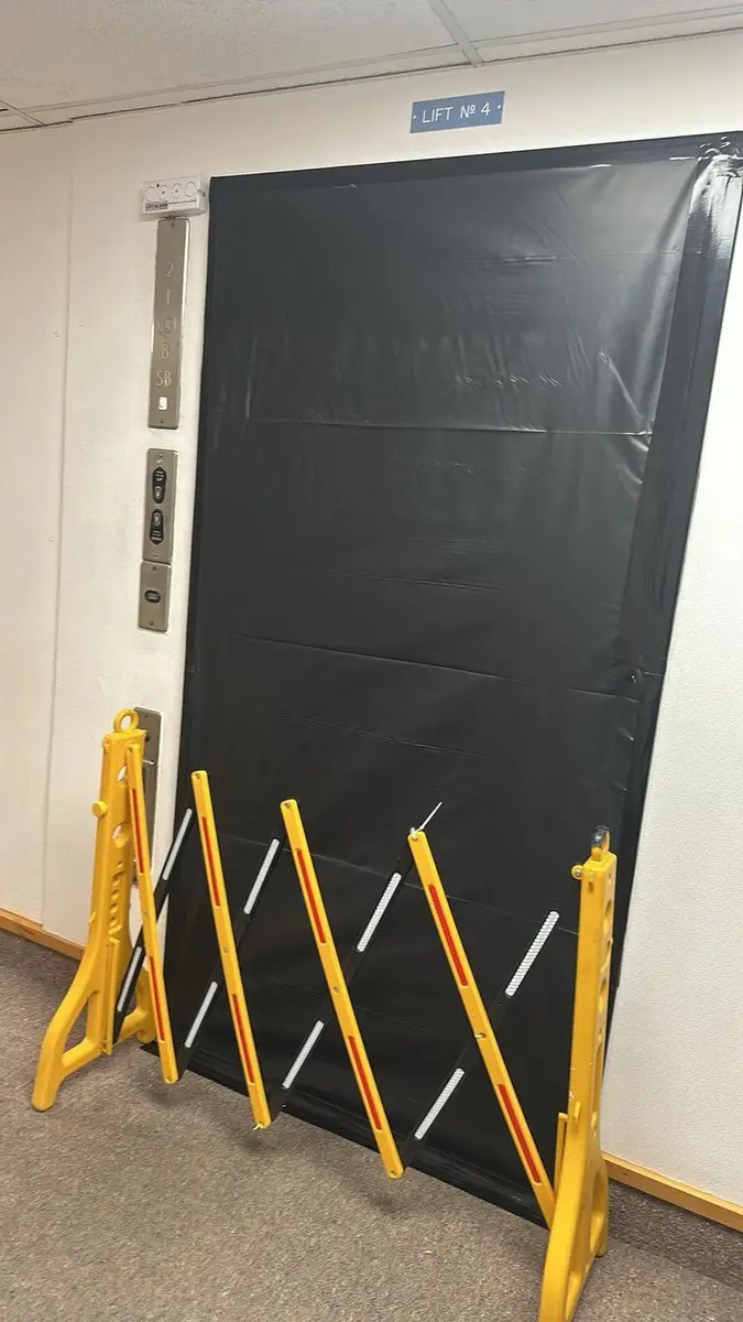 Black poly sealed doorway with expanding barrier during asbestos removal