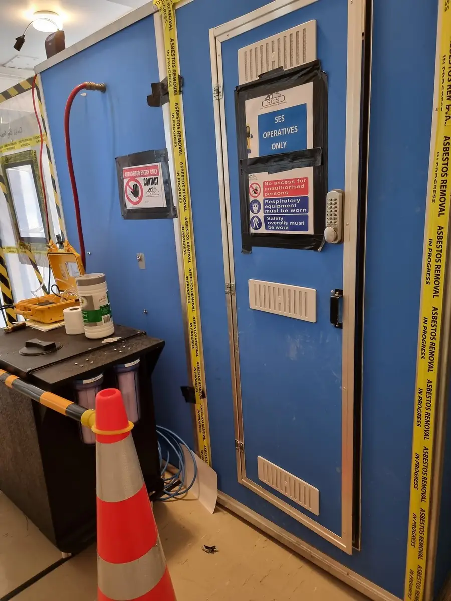 Blue decontamination unit door with signage in a commercial building