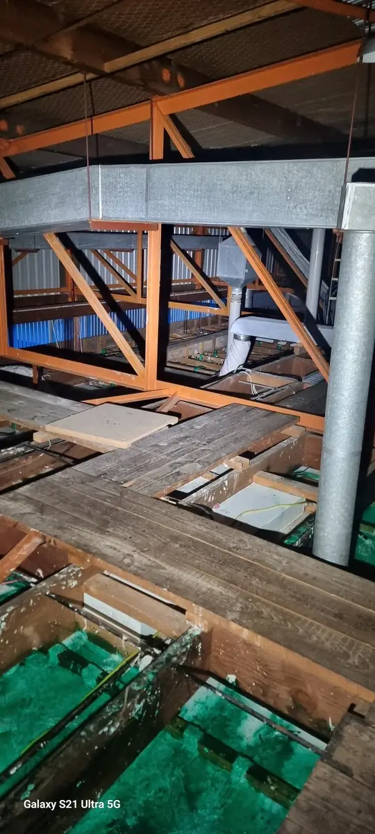 Wide view of timber joists and ductwork in the ceiling void