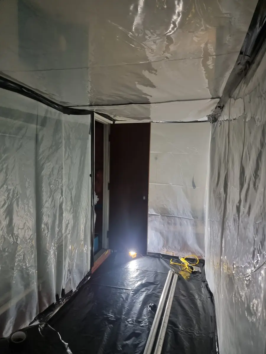 Sheeted corridor inside a Class A asbestos enclosure in a commercial building