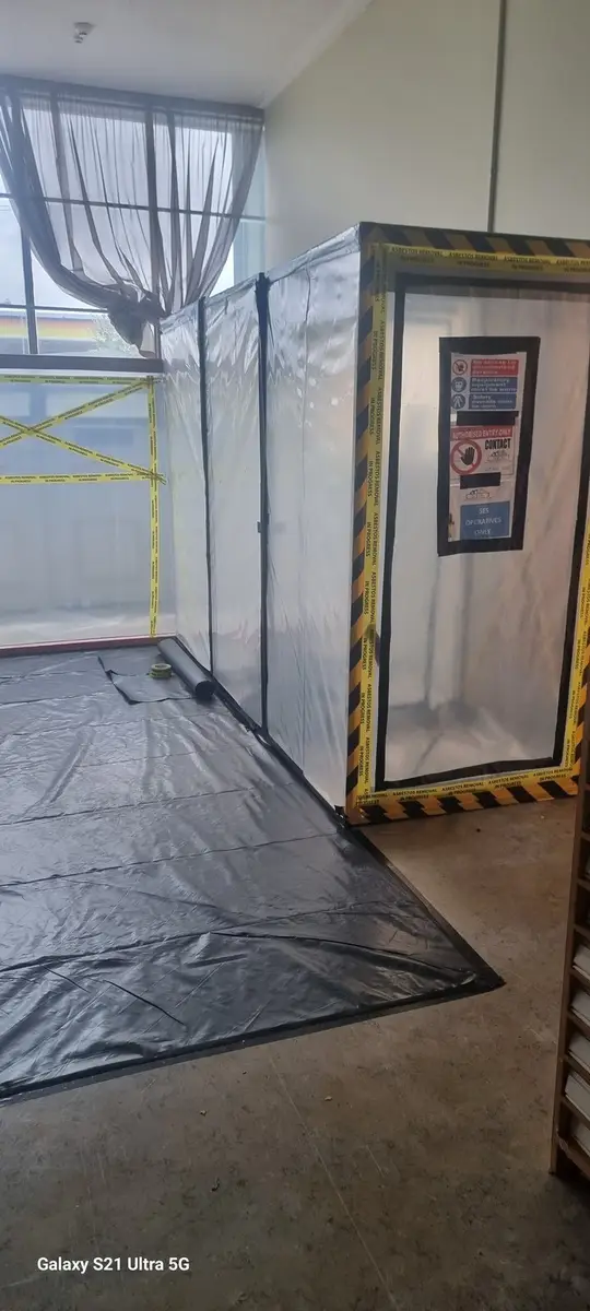 Sheeted partition sealing the corridor for asbestos removal in an office
