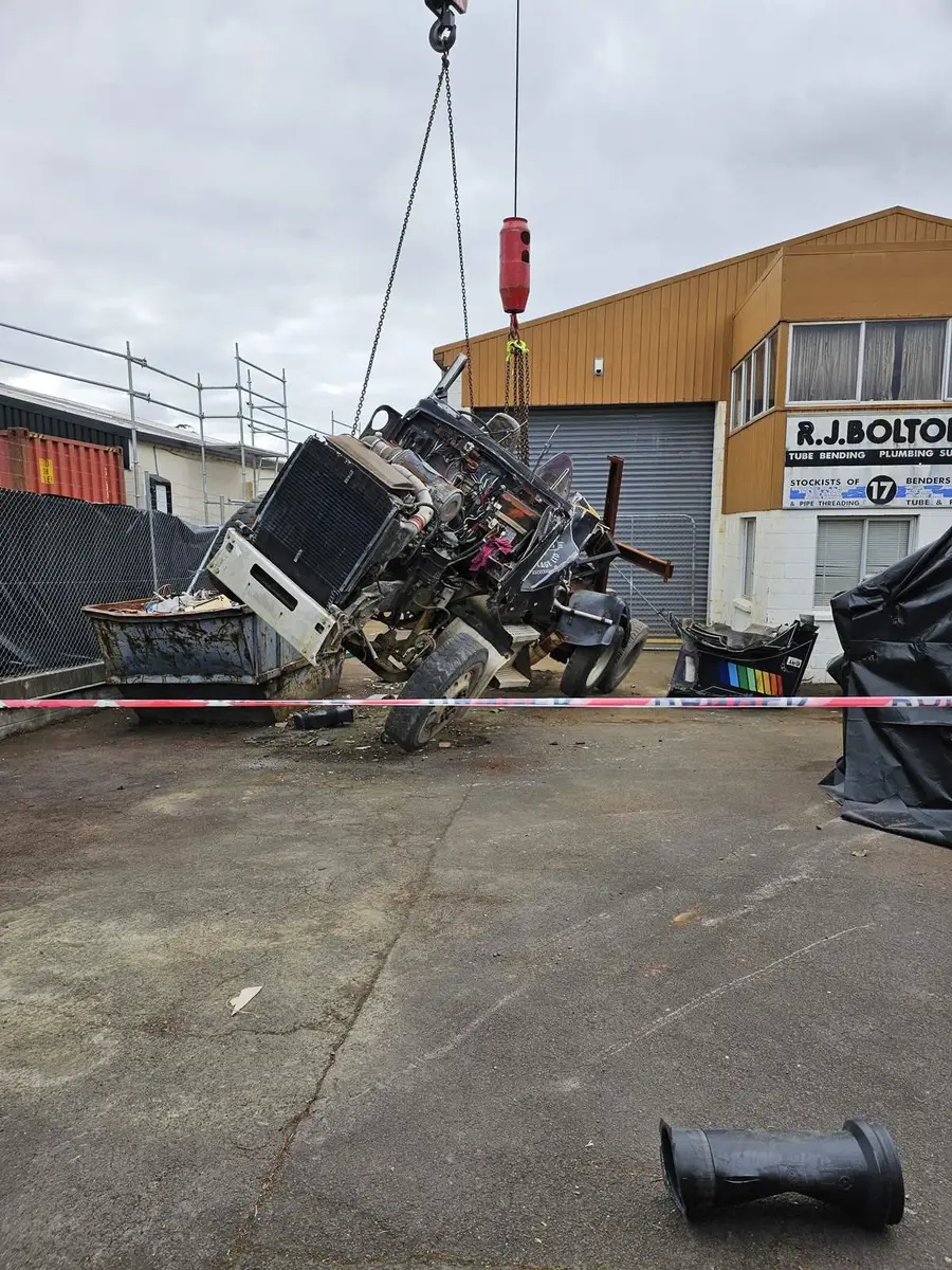 Crane lift of contaminated plant inside a taped exclusion zone