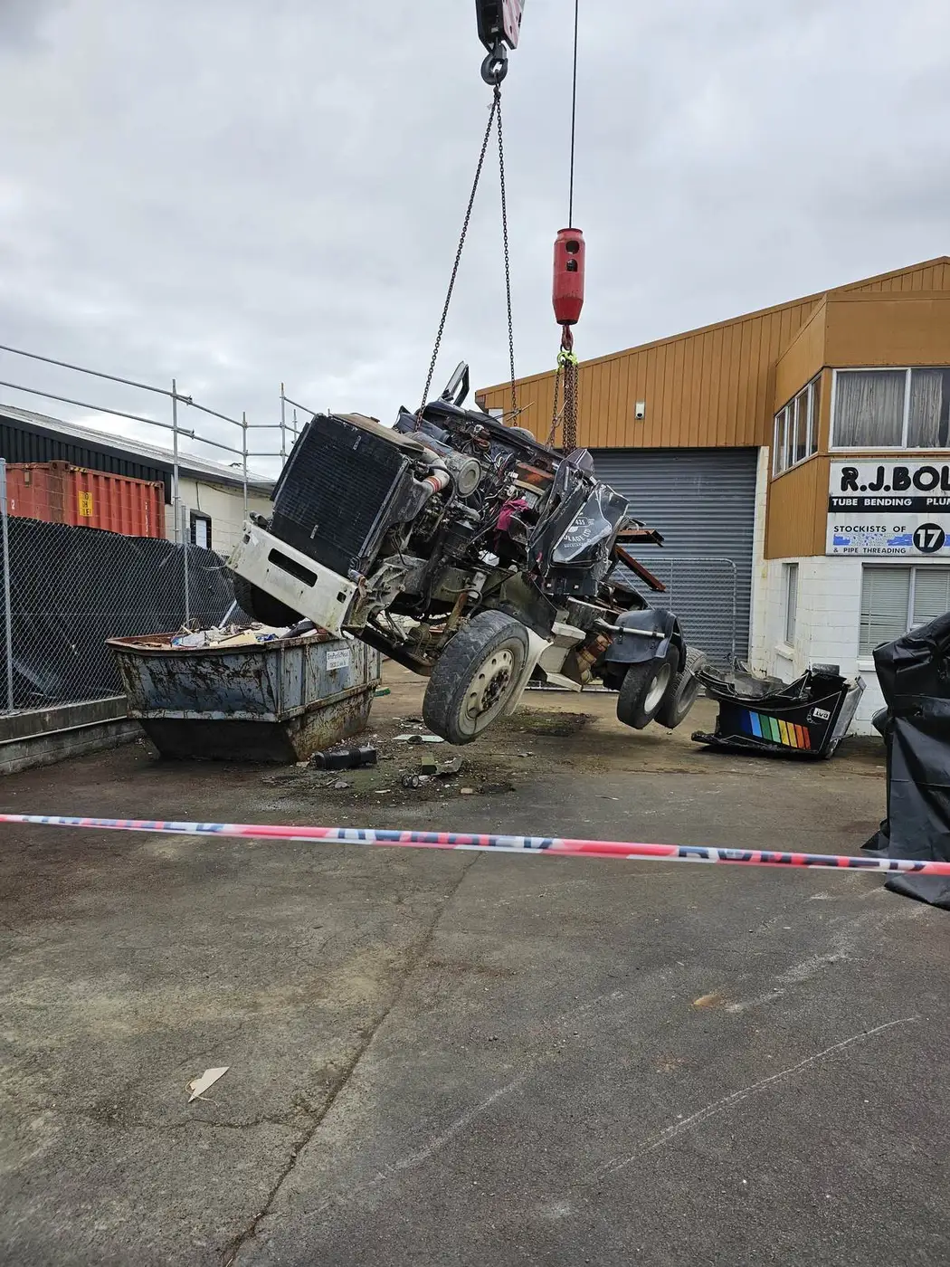 Crane lifting asbestos-contaminated plant in an industrial yard