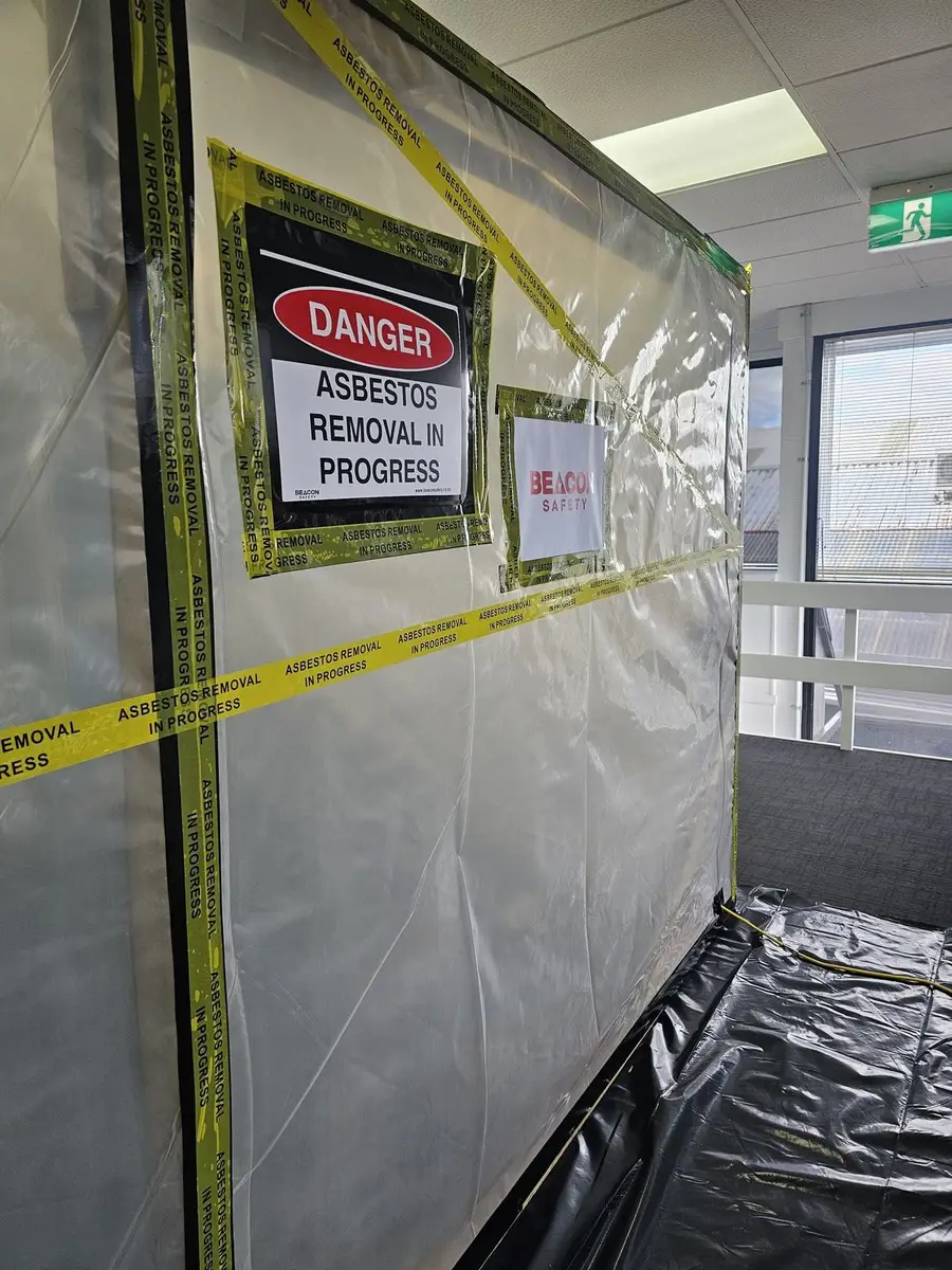 Danger - asbestos removal in progress sign on the enclosure wall