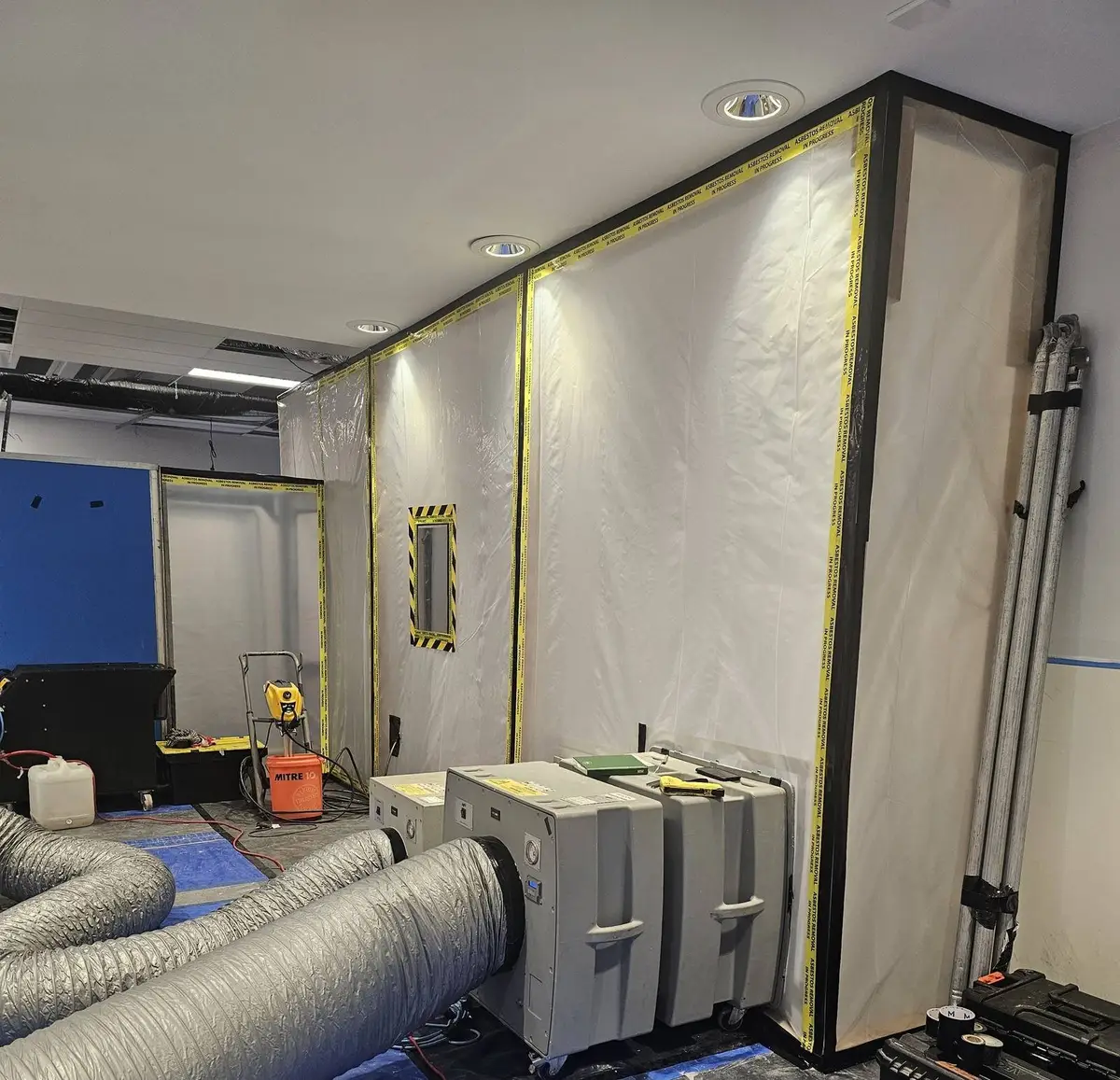 Enclosure corner with negative air units and blue decontamination unit