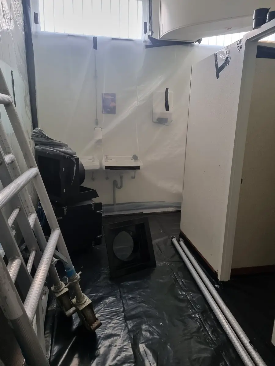 Negative air unit at the end of the sheeted enclosure corridor