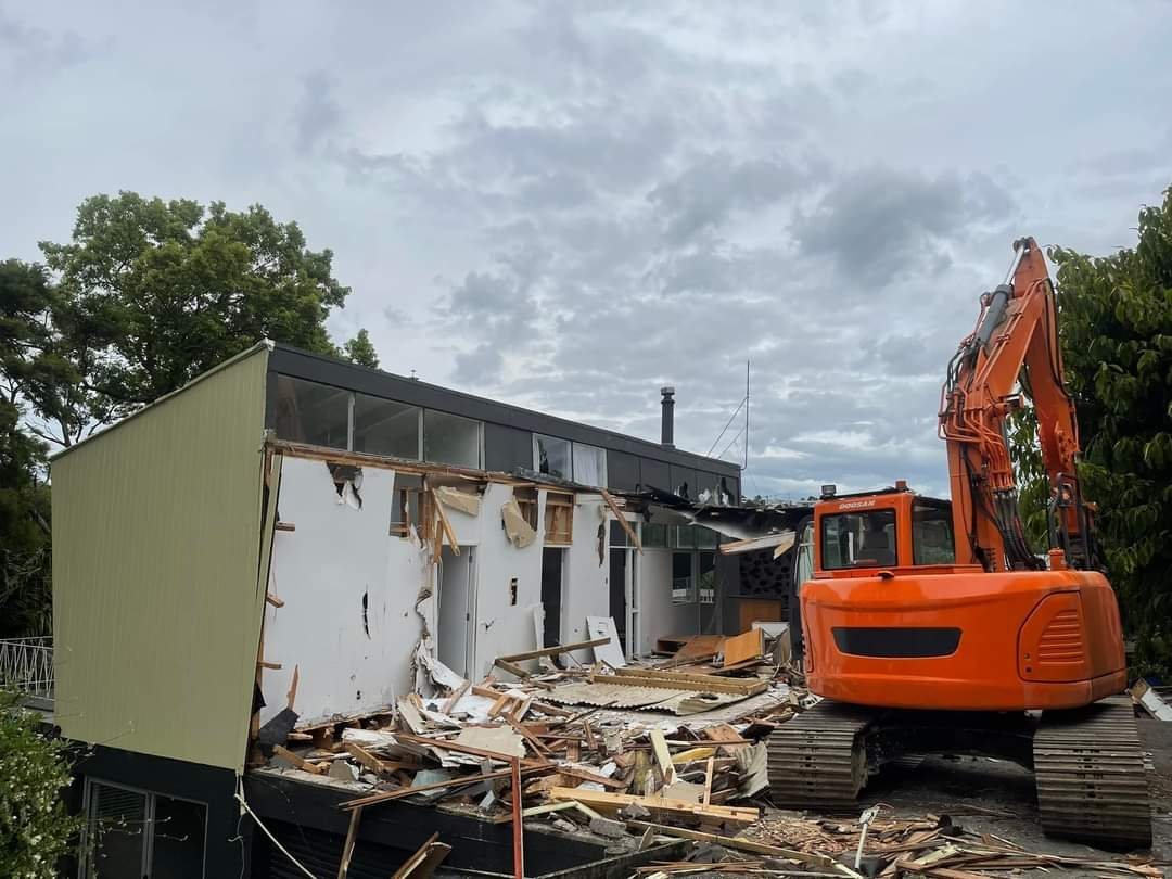 Excavator demolishing the house at the sub-division site