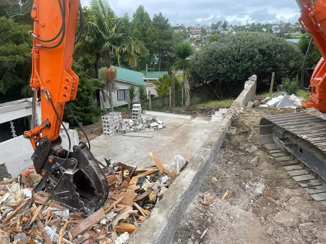 Excavator grab sorting rubble and timber during demolition