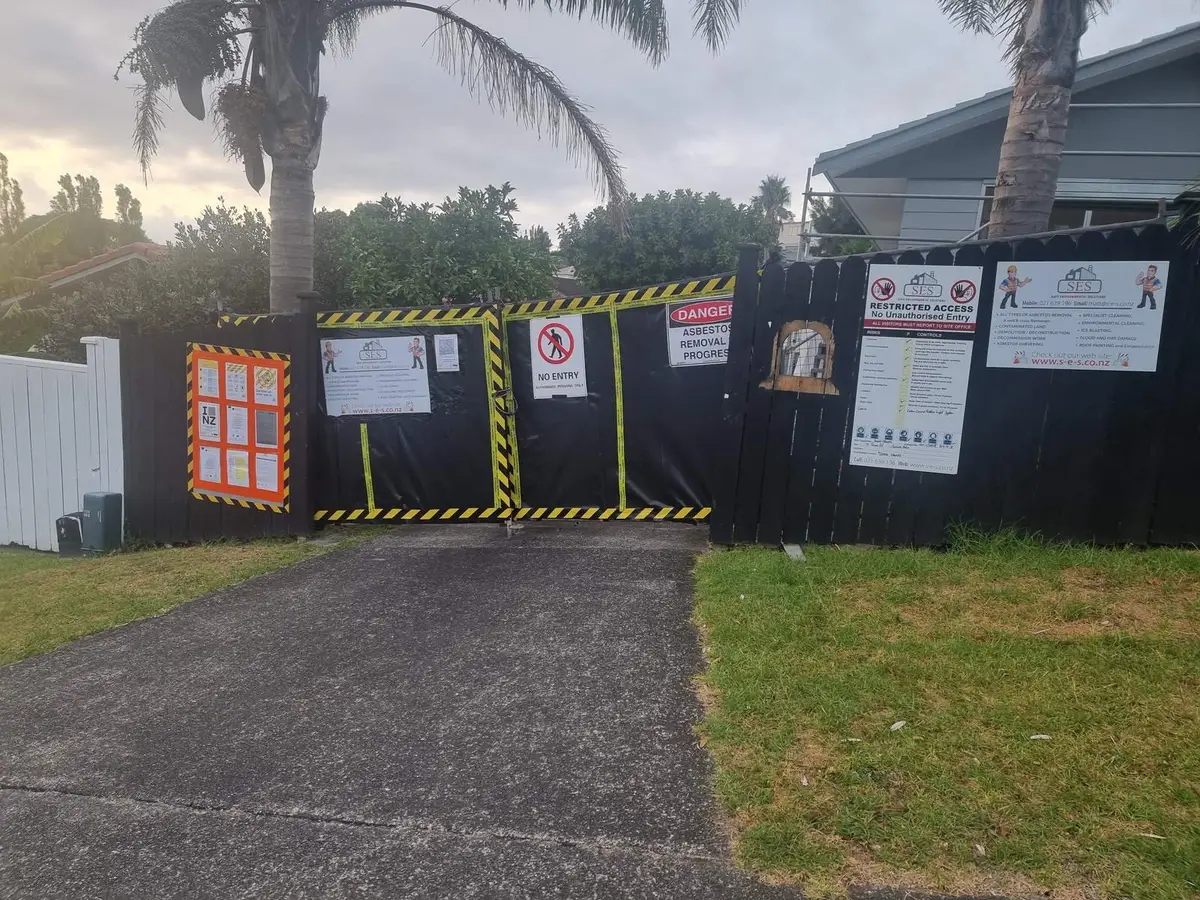 Fence hoarding and signage around the two-storey house