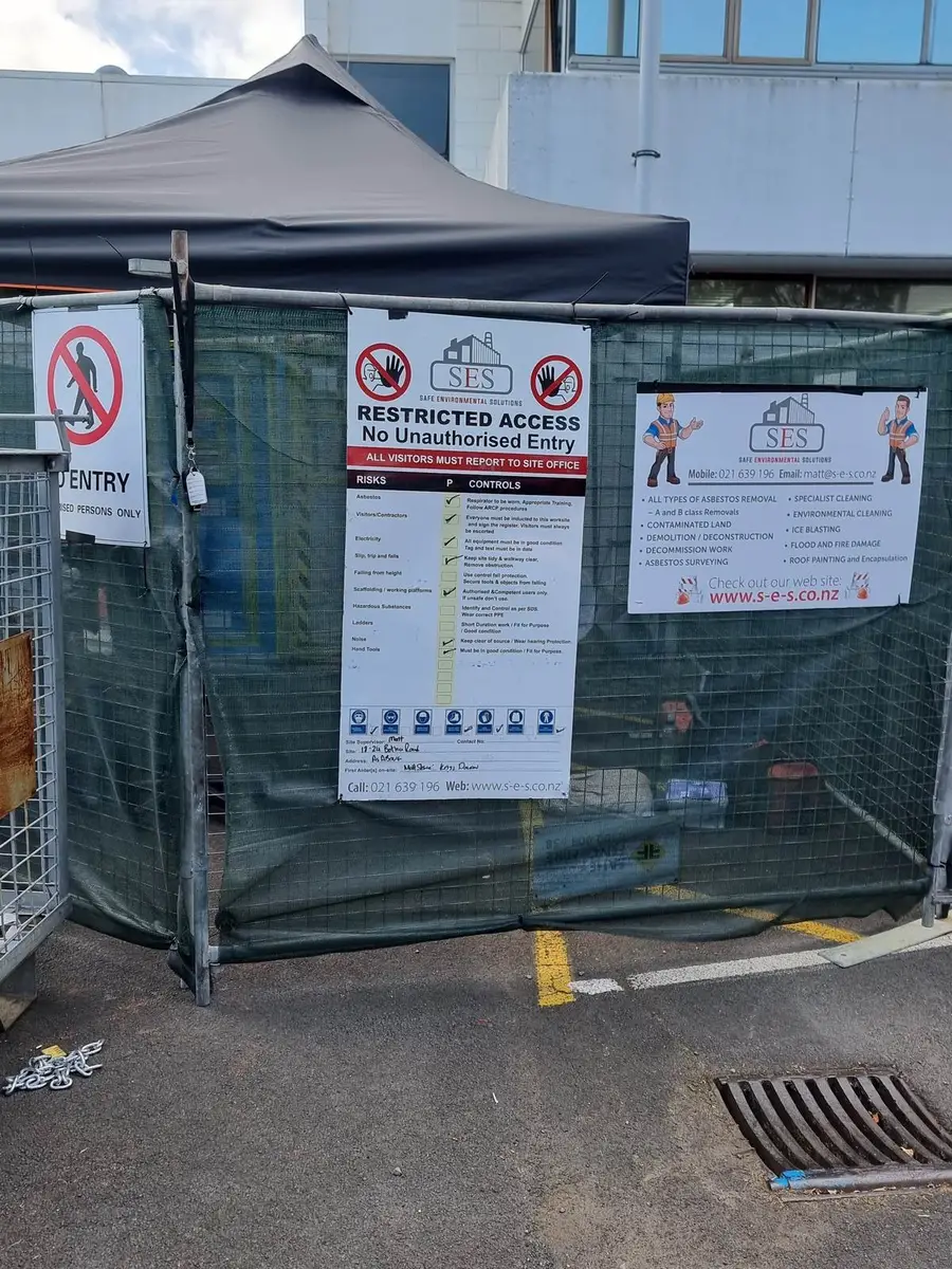 Fenced compound with signage at the commercial asbestos removal