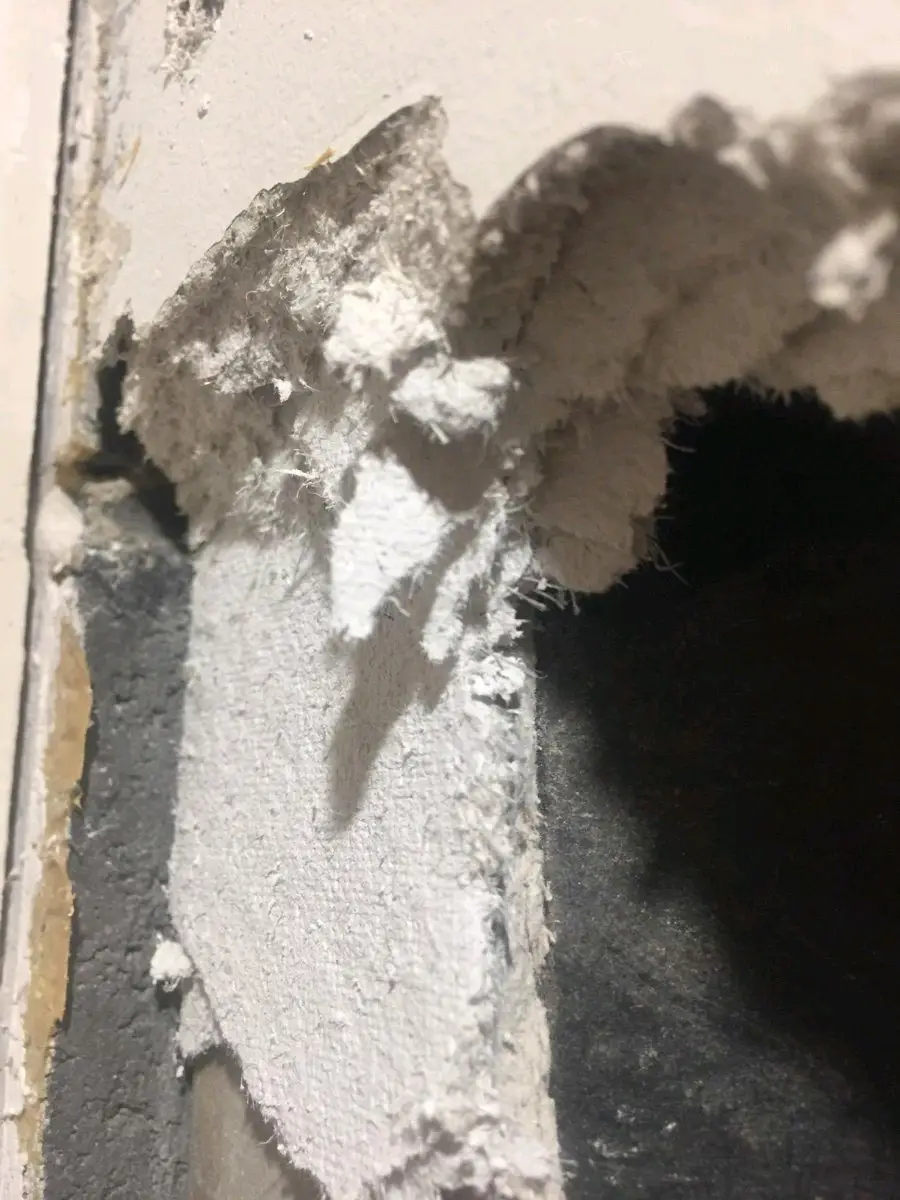 Close-up of friable asbestos insulation material removed from the structure