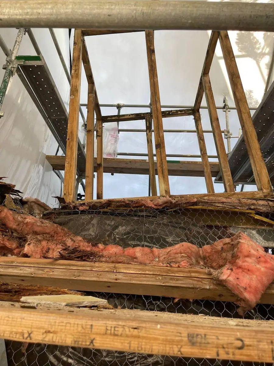 Insulation batts exposed inside the asbestos-cement hood during removal