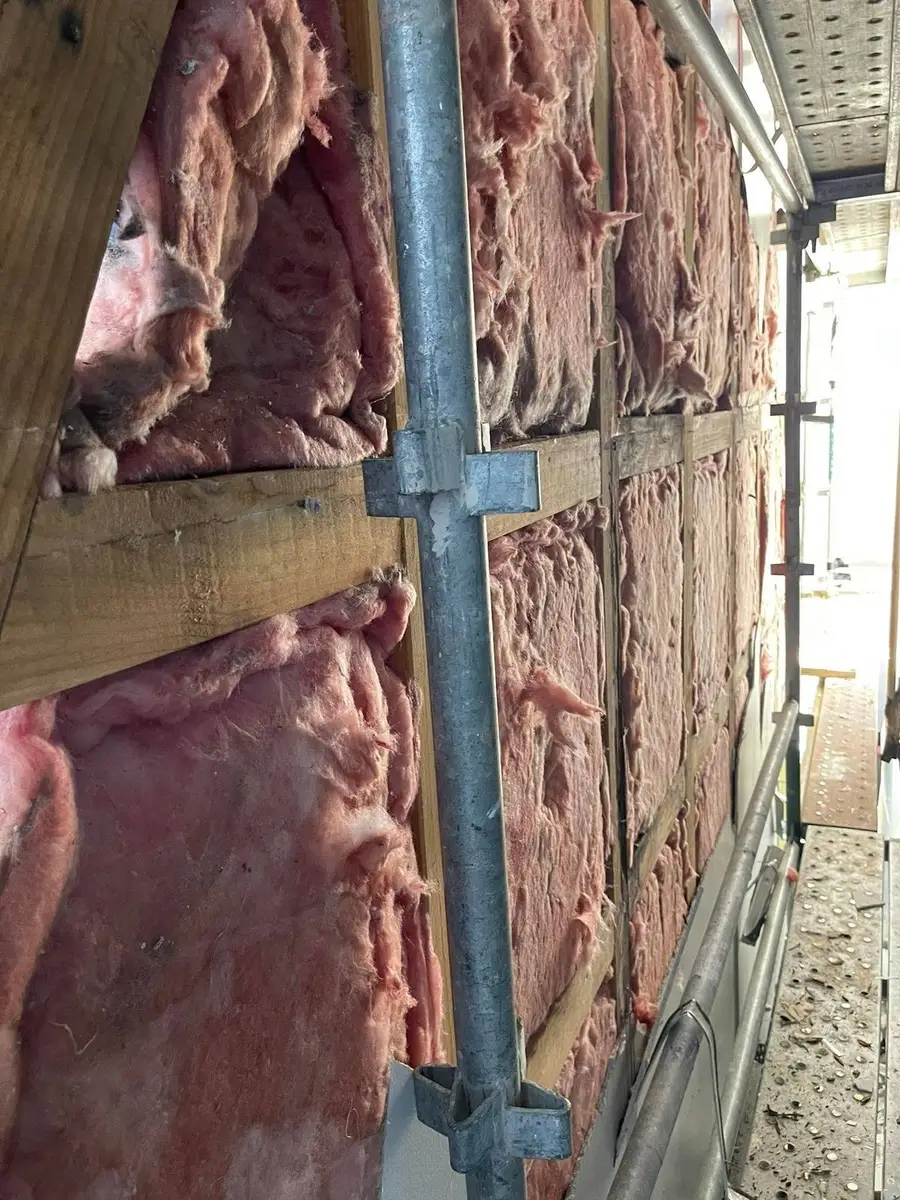 Insulation batts against the scaffold enclosure wall during removal