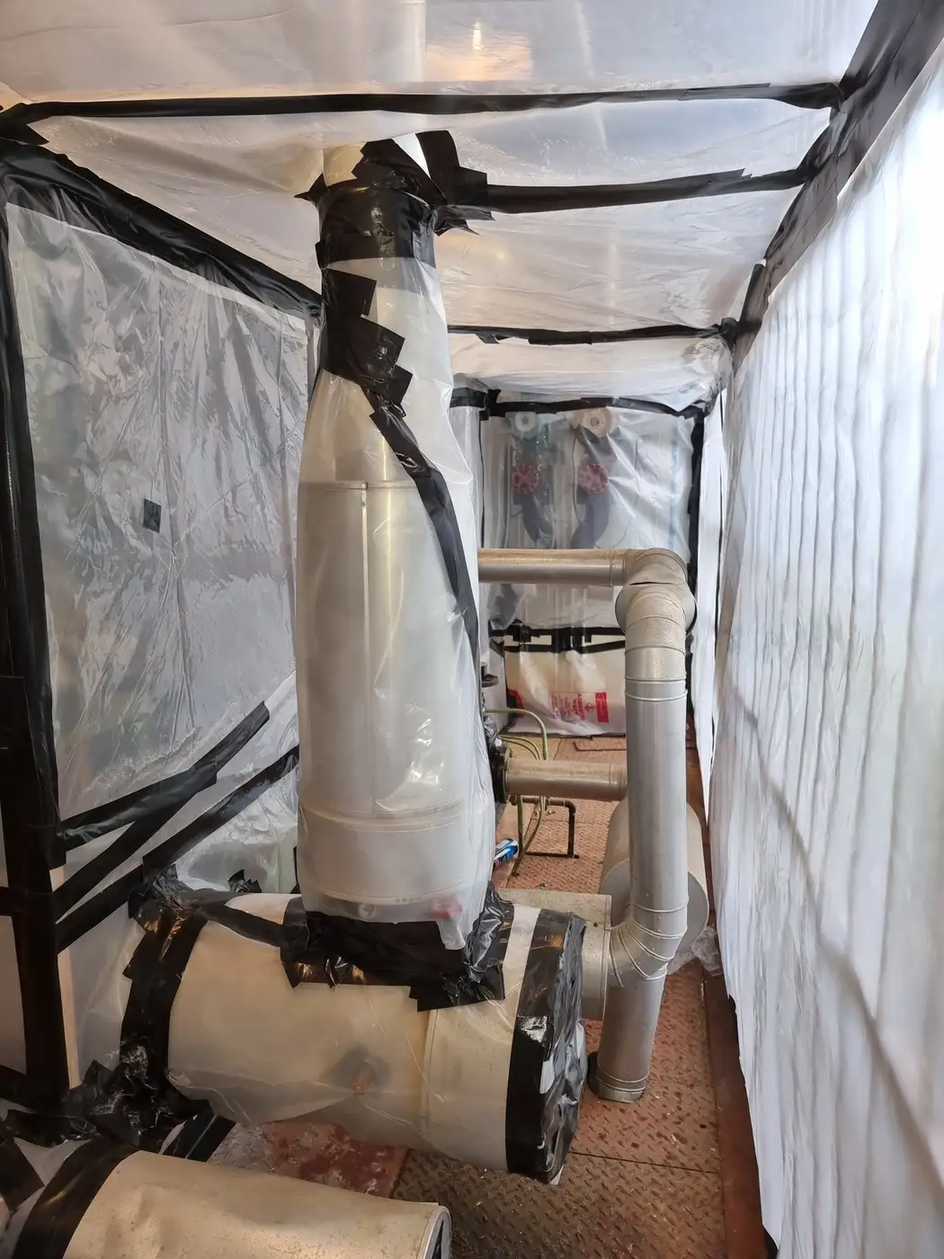 Lagged pipework inside the asbestos enclosure in the plant room
