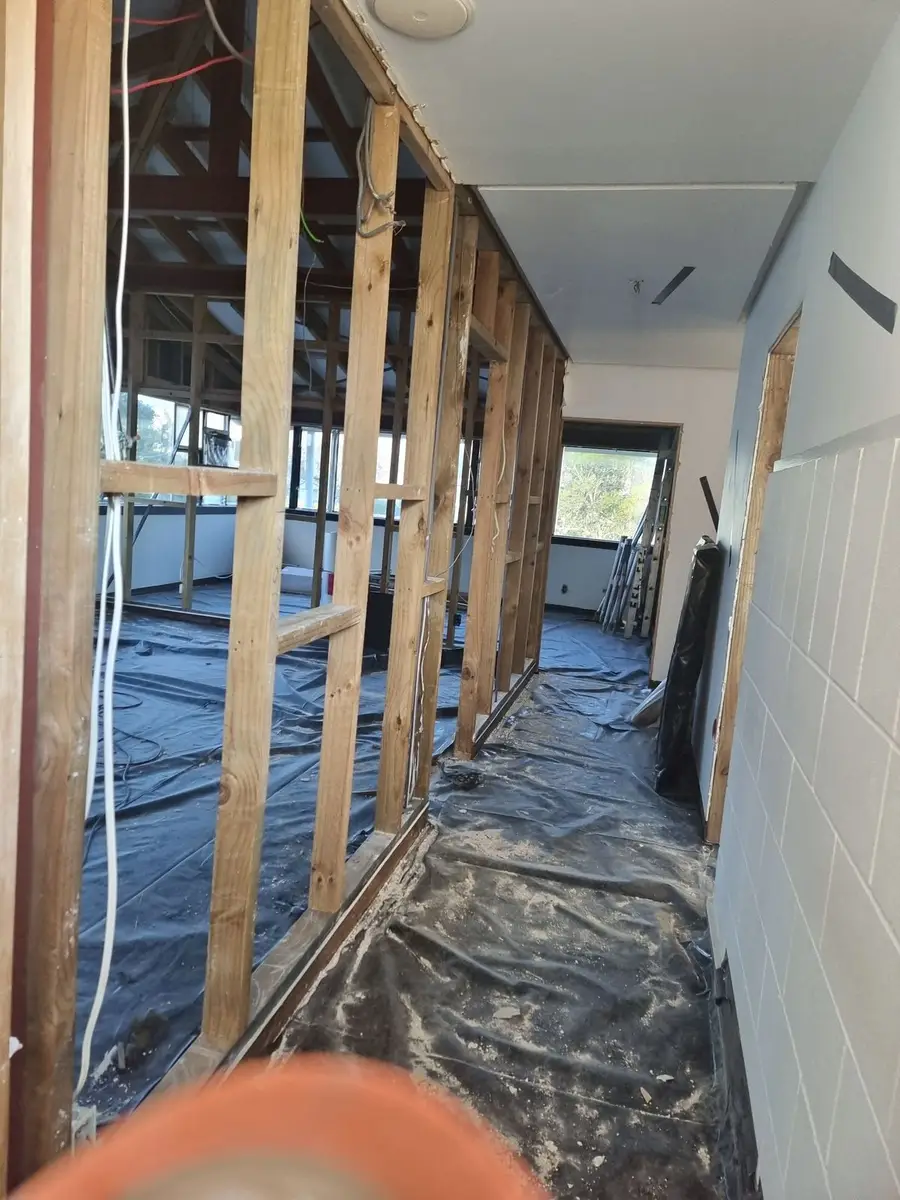 Office corridor stripped back to framing during the soft-strip