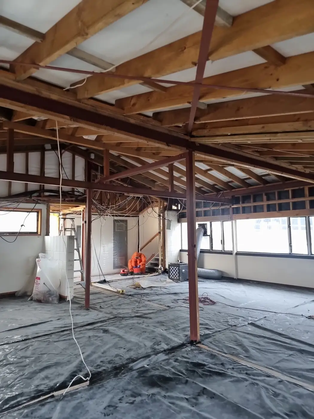 Open-plan office stripped to framing and roof trusses