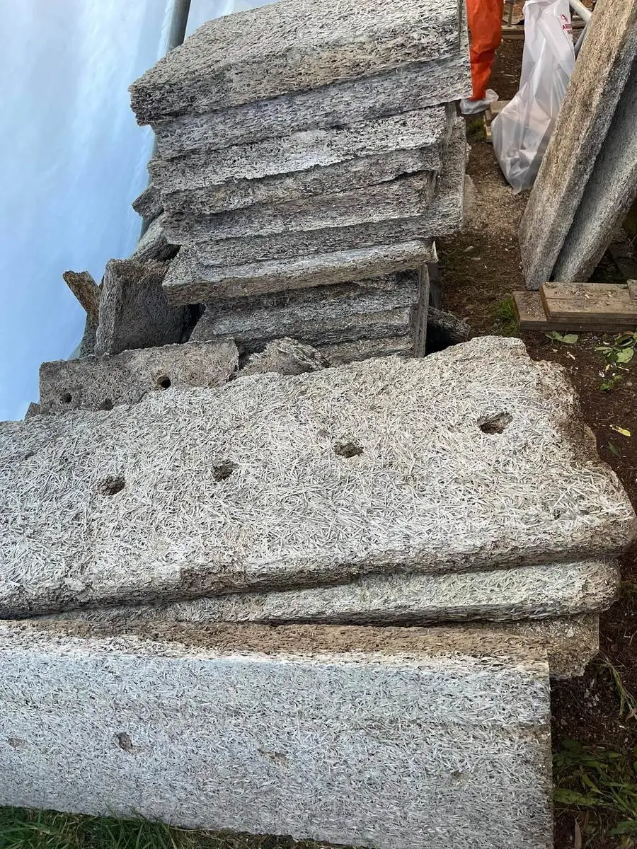 Removed asbestos-cement sheets stacked ready for wrapping and licensed disposal