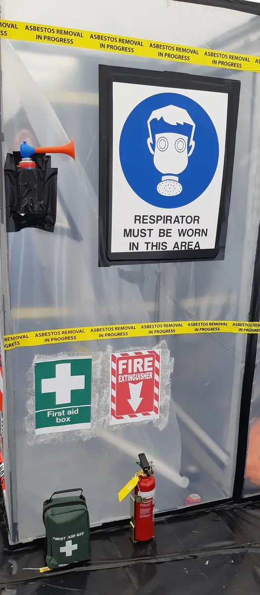 Respirator must be worn sign on the asbestos enclosure