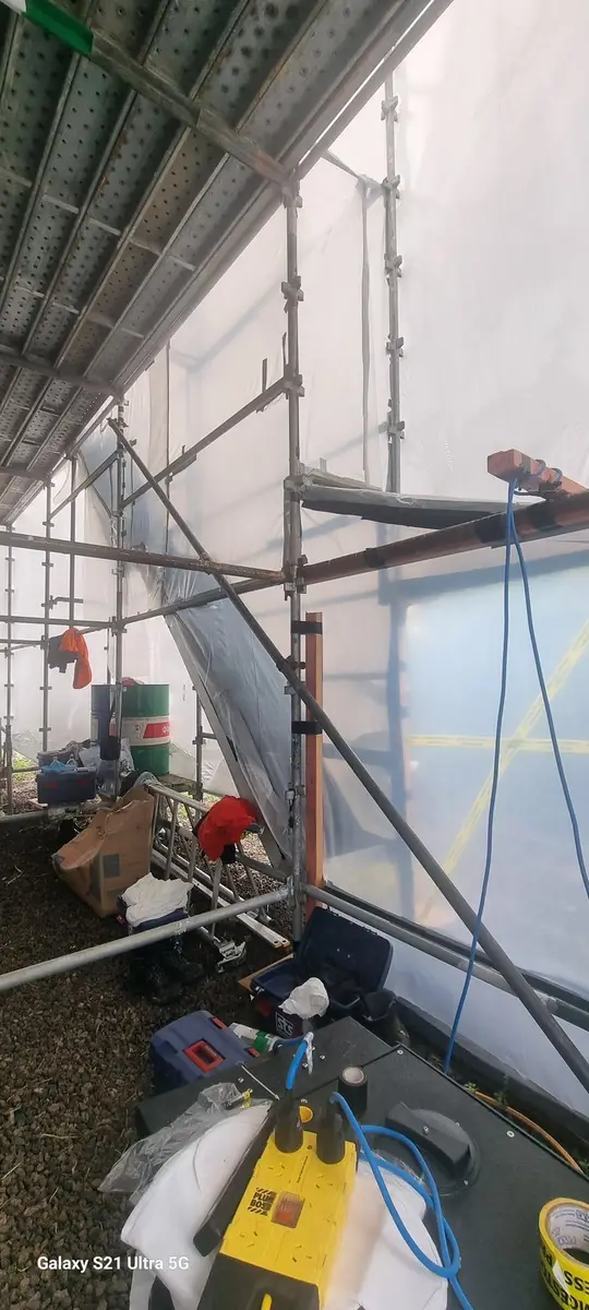 Inside the scaffold wrap enclosure on the industrial building
