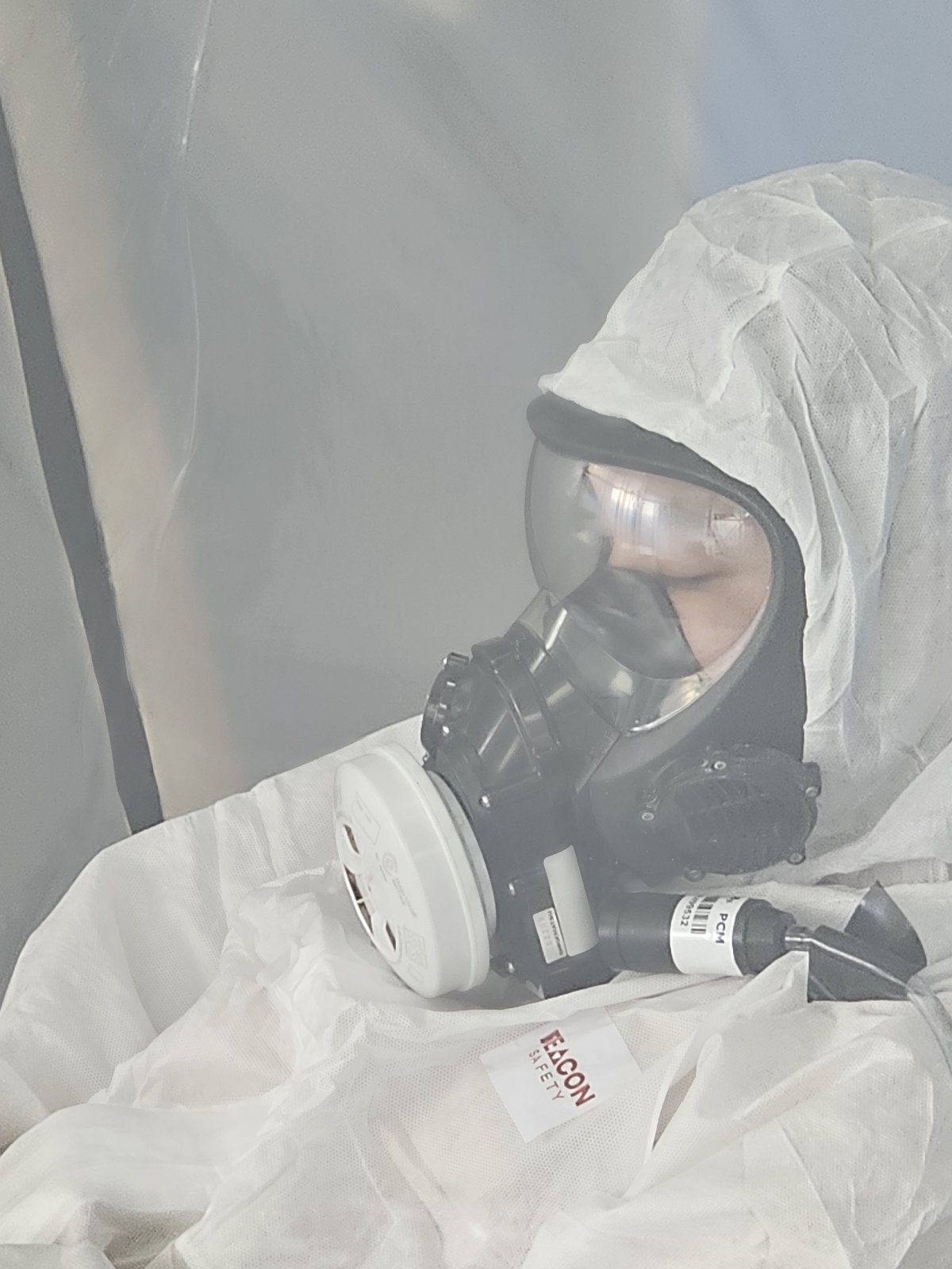 SES asbestos operative in a full-face respirator and disposable coveralls