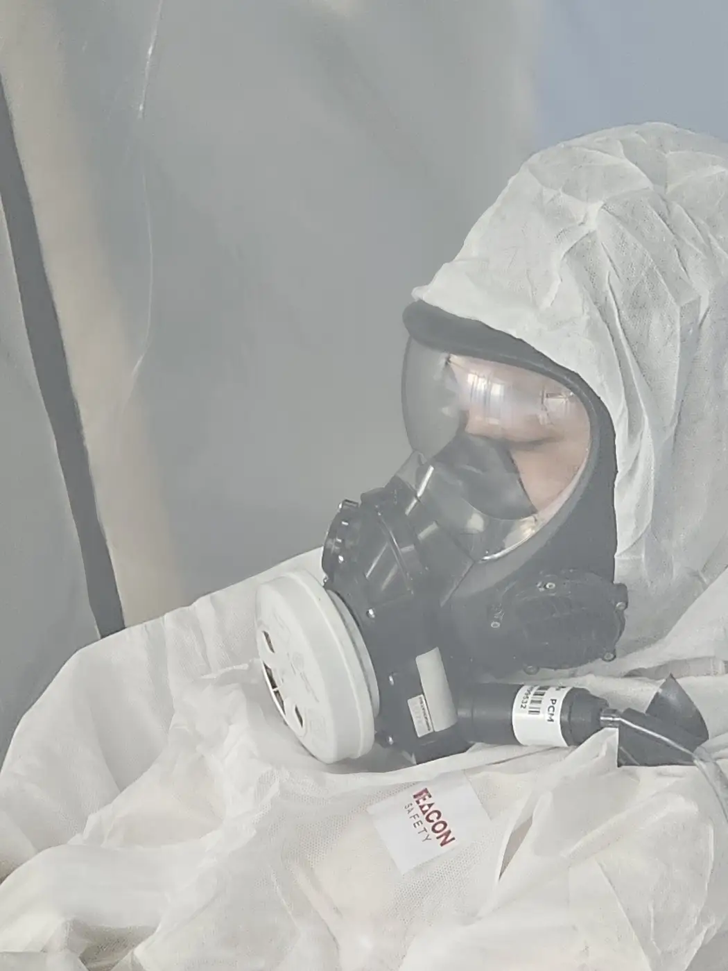 SES asbestos operative in a full-face respirator and disposable coveralls
