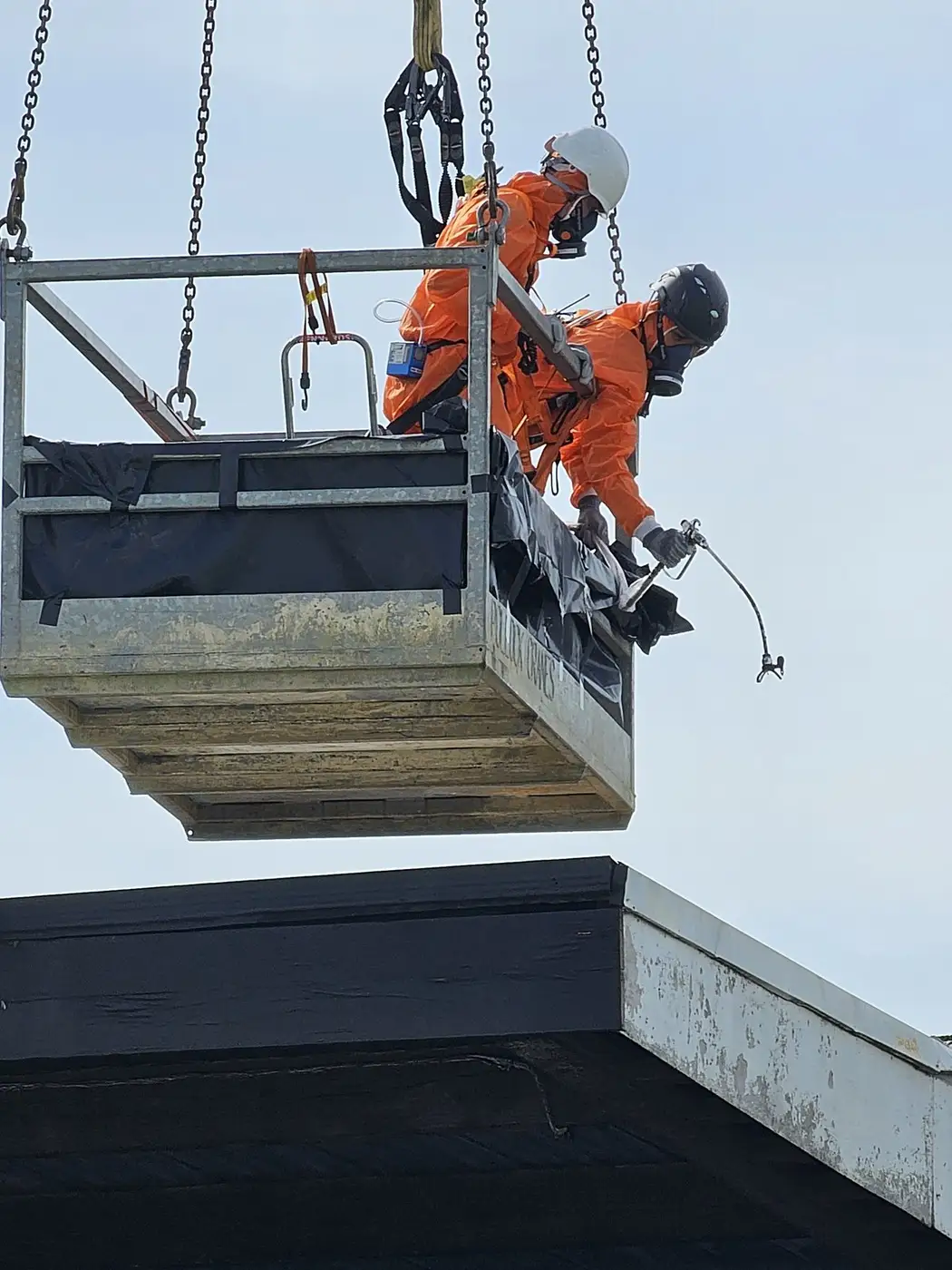 SES operative on a crane work platform during an asbestos roof lift