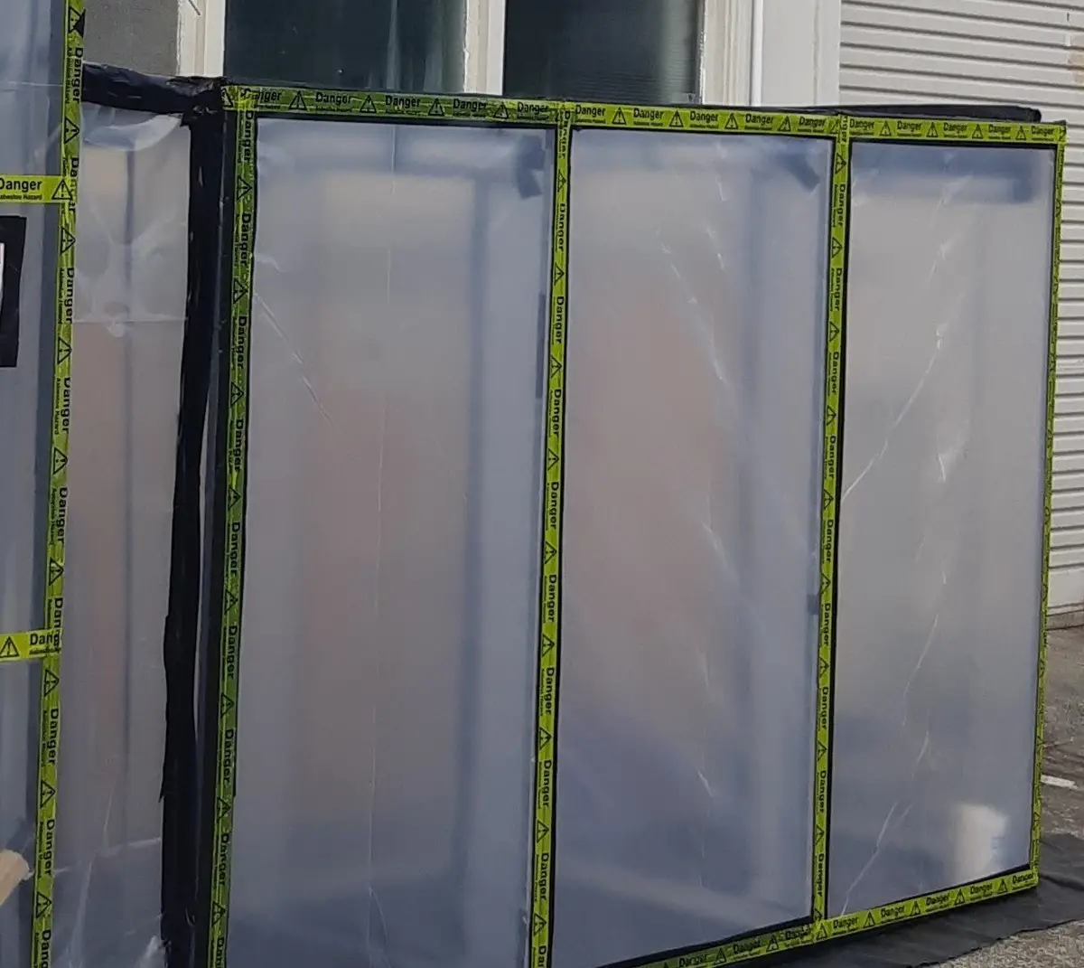 Sheeted asbestos enclosure on the exterior of a house