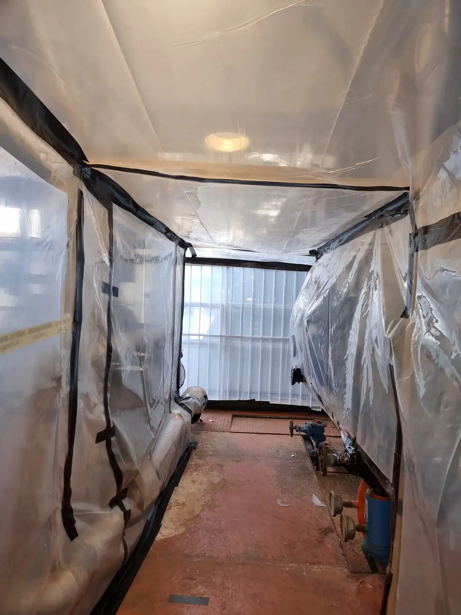 Sheeted enclosure around plant room pipework