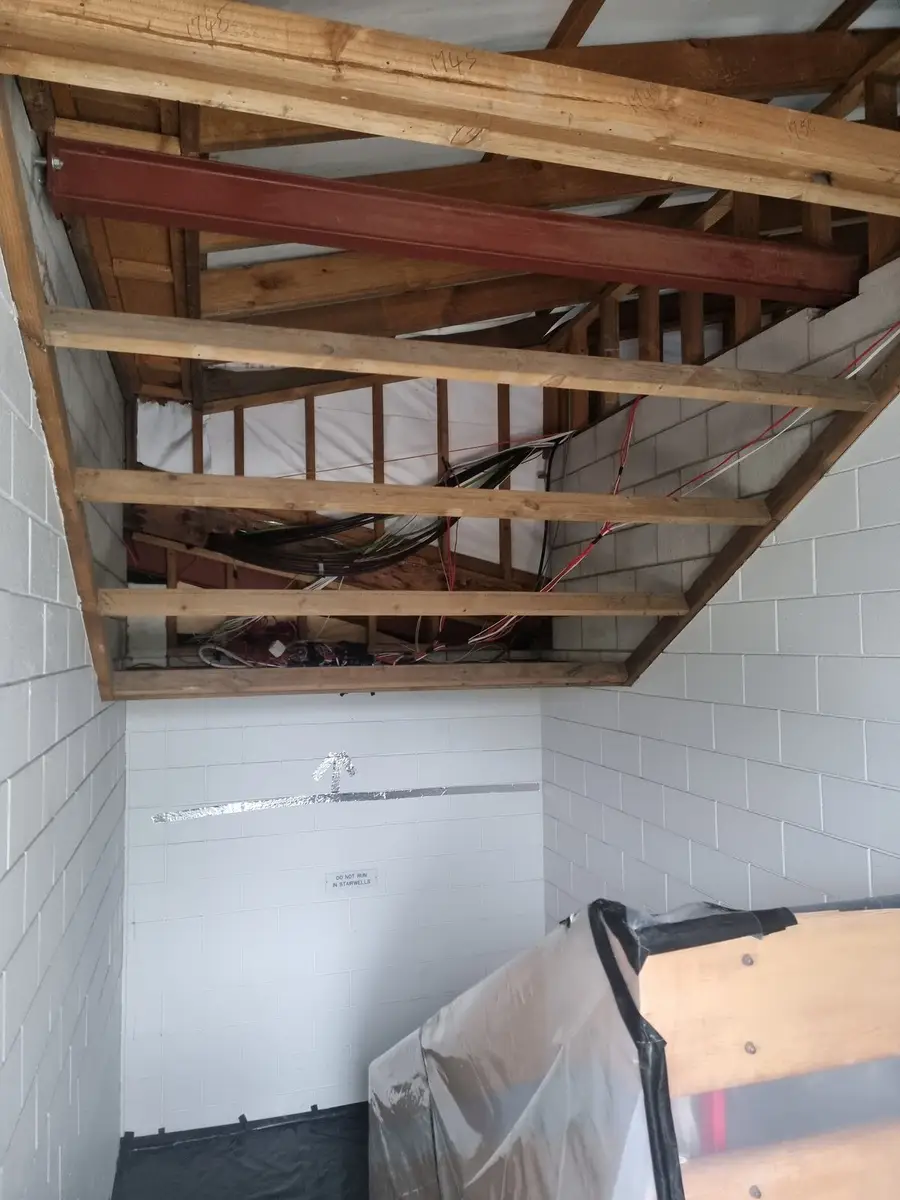 Stairwell framing exposed during the office soft-strip