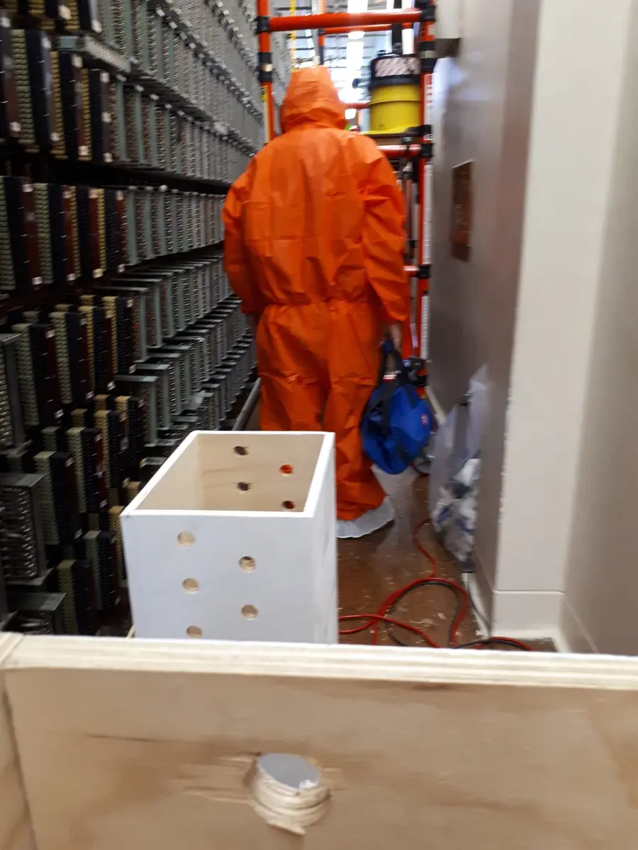 SES operative in PPE working beside live telecommunications equipment