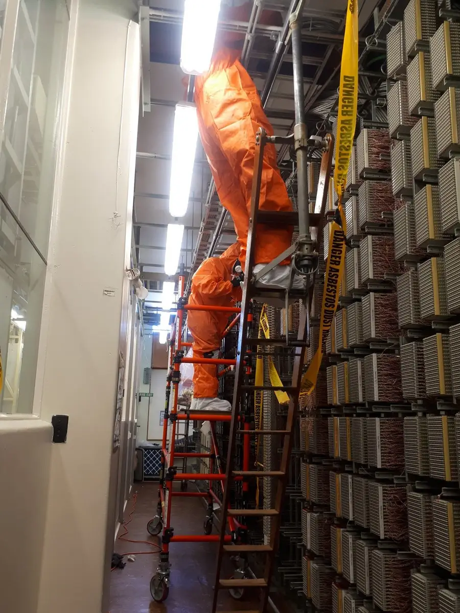 Asbestos removal in the equipment aisle of a telecommunications exchange