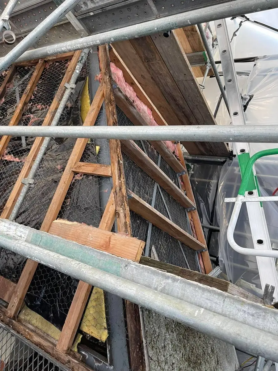 Timber framing being dismantled inside the enclosure during the asbestos hood removal