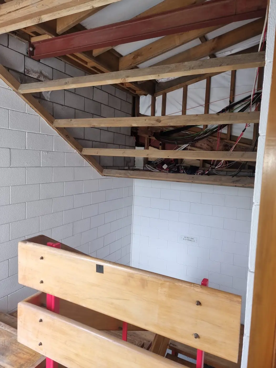 Timber stair balustrade and block wall during the office strip