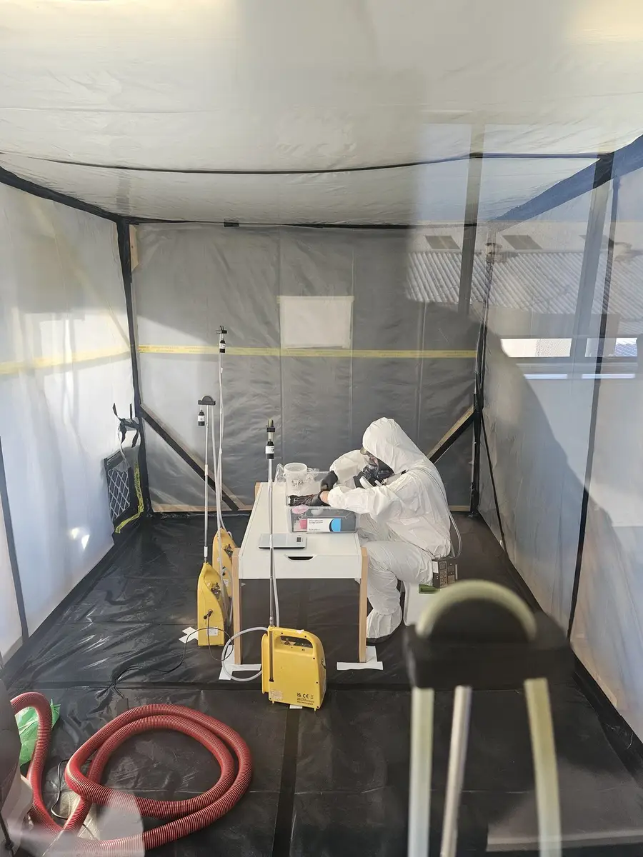 Two SES operatives in PPE inside the enclosure with air monitoring running